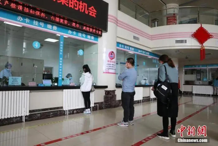 资料图:市民在医院门诊大厅间隔排队挂号。中新社记者 杨迪 摄 图片